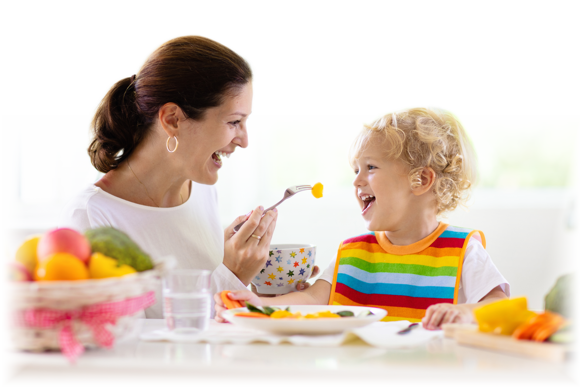 Mãe alimentando uma criança pequena durante uma refeição